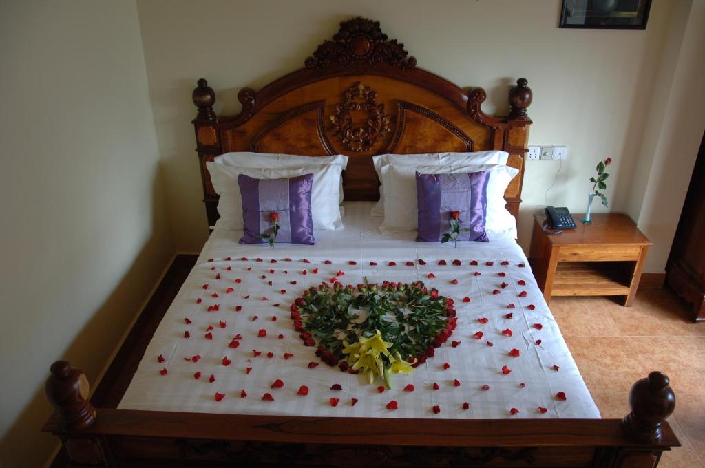 Un dormitorio con una cama con un corazón hecho de rosas en Lux Guesthouse en Battambang