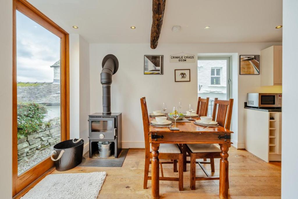 een eetkamer met een tafel en een houtkachel bij 2 Bed in Troutbeck oc-c33392 in Troutbeck