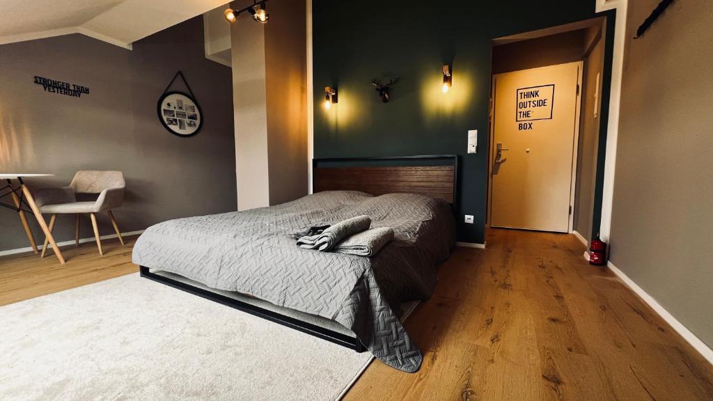- une chambre avec un lit et un couloir avec une chaise dans l'établissement Apartment near Sana Klinik, à Offenbach-sur-le-Main