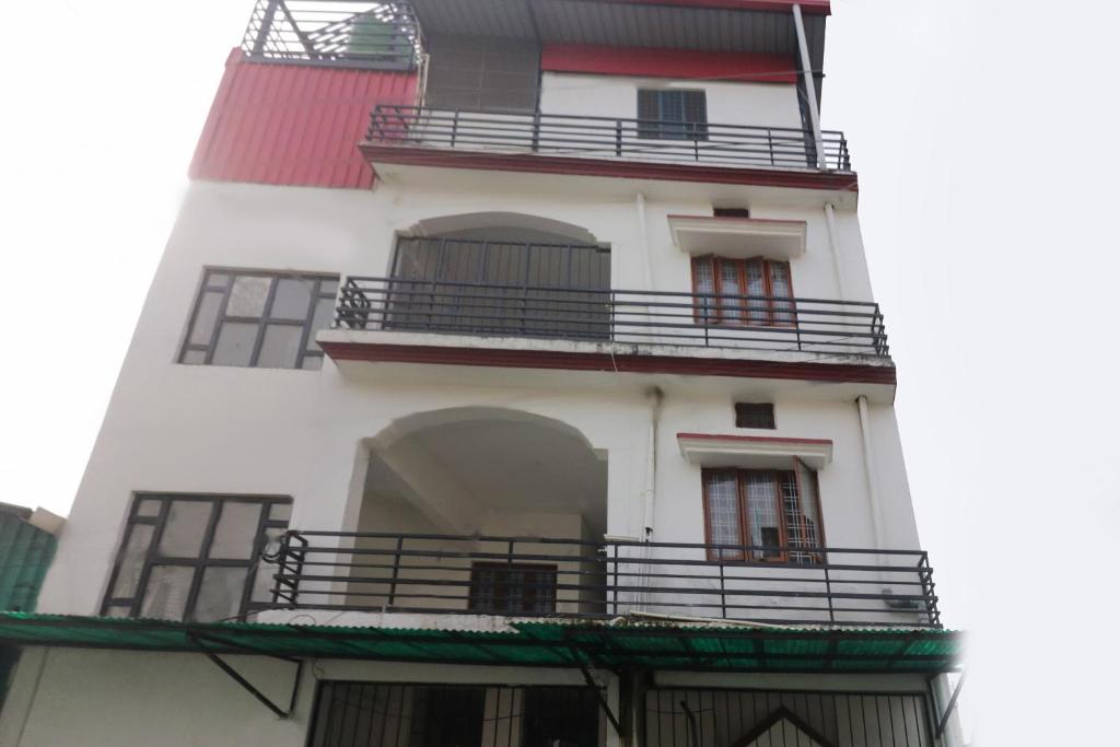 a white building with balconies on the side of it at SPOT ON Sneha Home Stay in Dehradun