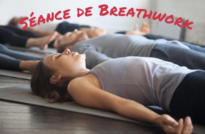 eine Gruppe von Leuten, die in einem Yoga-Kurs auf dem Boden liegen in der Unterkunft LE COCON - Calme et Ressourcement in Rouffach