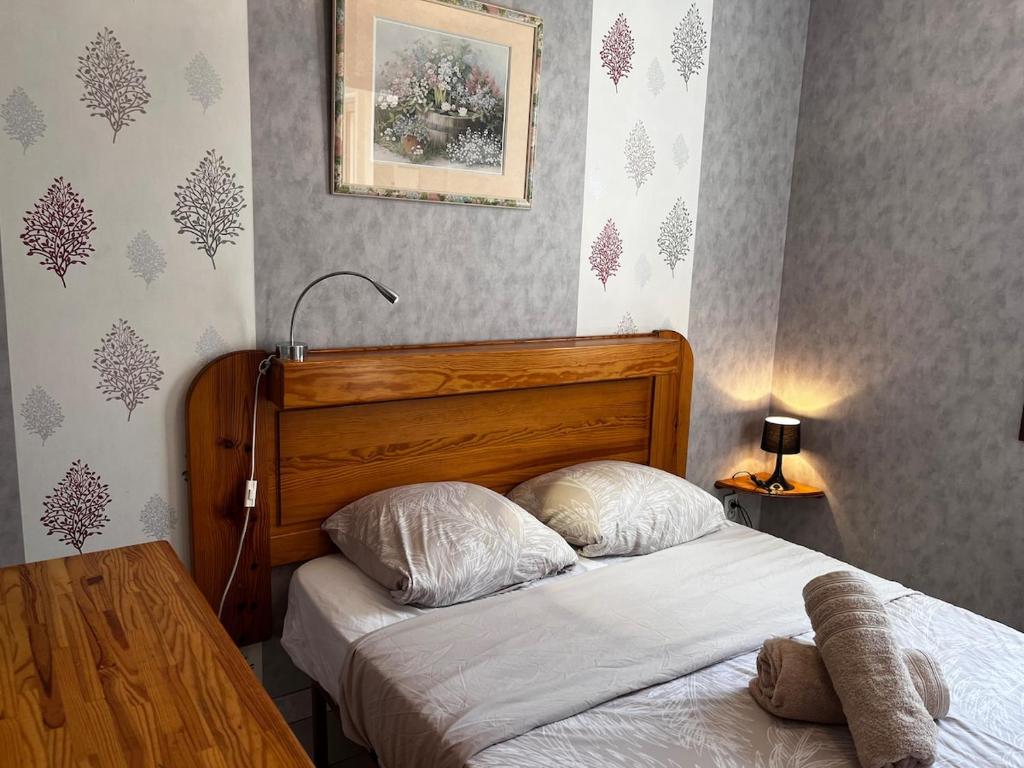 Lys des Pyrénées في آكس ليه تيرم: غرفة نوم مع سرير مع لوح خشبي للرأس