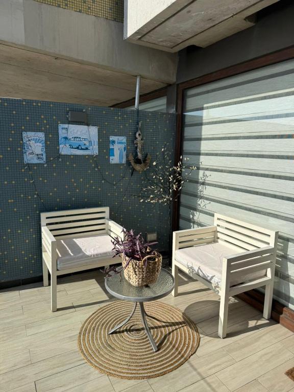 two benches and a table on a patio at HOM Depto 4PAX con Parking En cerro Baron in Valparaíso