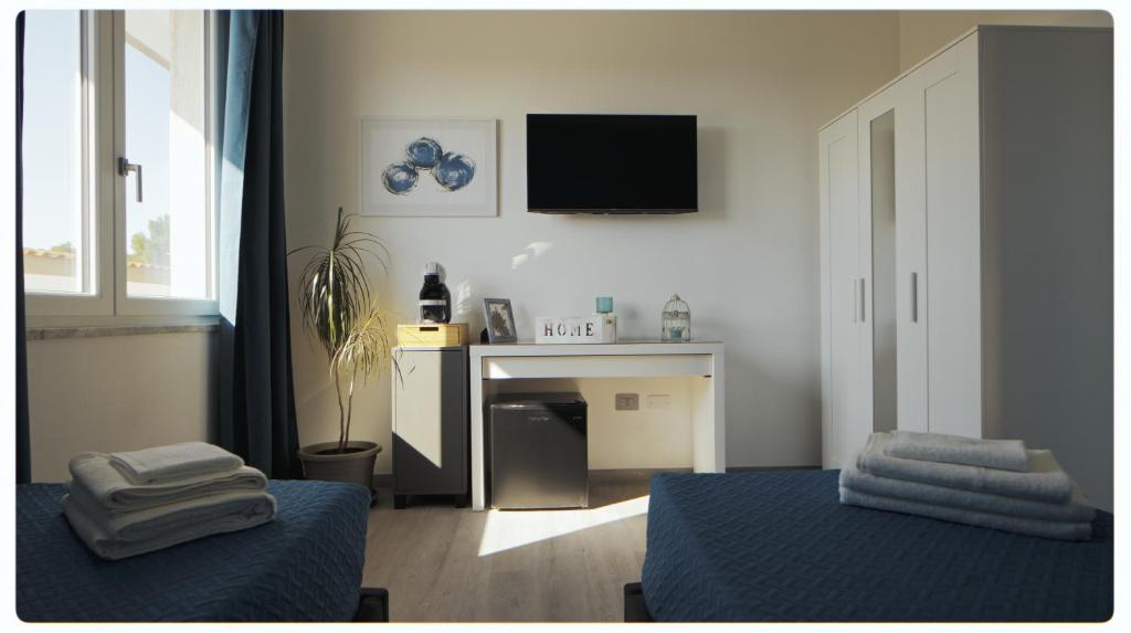 un soggiorno con letto e TV a parete di Mhometredici Camera doppia Otello a Sestu