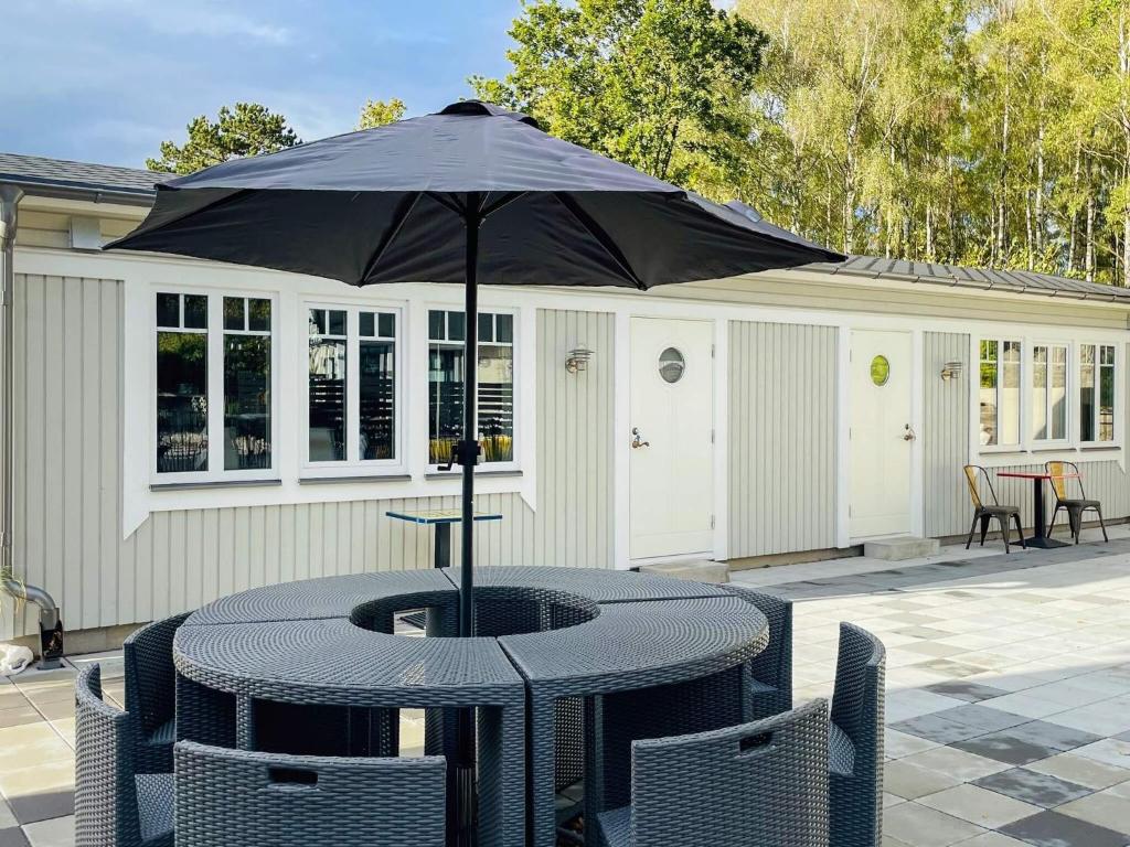 a table with an umbrella on a patio at 4 person holiday home in SÖLVESBORG in Hällevik
