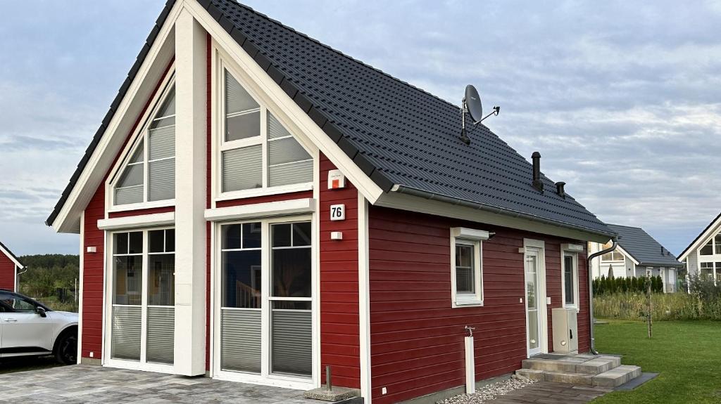una casa roja con un techo negro y un coche en Nr. 496 Haus Biber, en Berg
