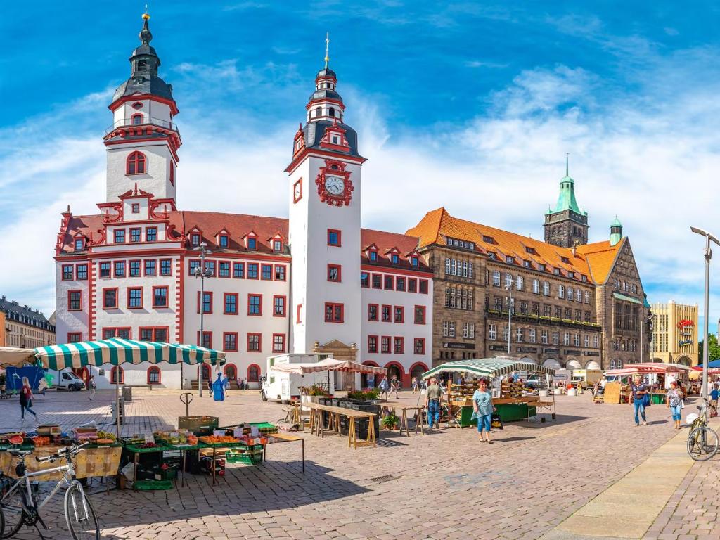 a group of buildings with a clock tower in a city at Atelier Noé NOIR - Kunstvoll Wohnen - Wunderbares Frühstück möglich - Ruhig und nah am Zentrum - in Chemnitz