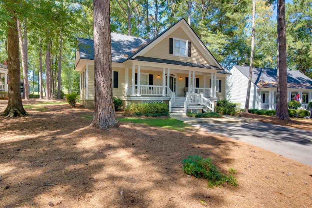 una casa blanca con un árbol delante en Stunning Lake Oconee Retreat with Pool Access!, en Turnwold