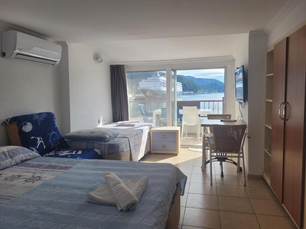 ein Hotelzimmer mit zwei Betten und Balkon in der Unterkunft Uysal Suite and Loft Seaside in Marmaris