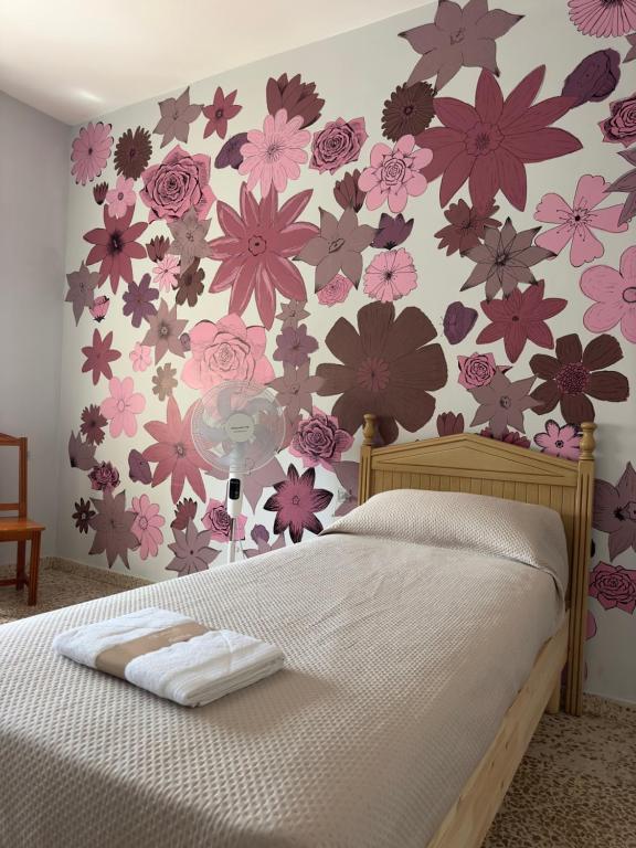 オルヒバにあるHostal Dar Alpujarraのベッドルーム1室(花の壁掛けのベッド1台付)