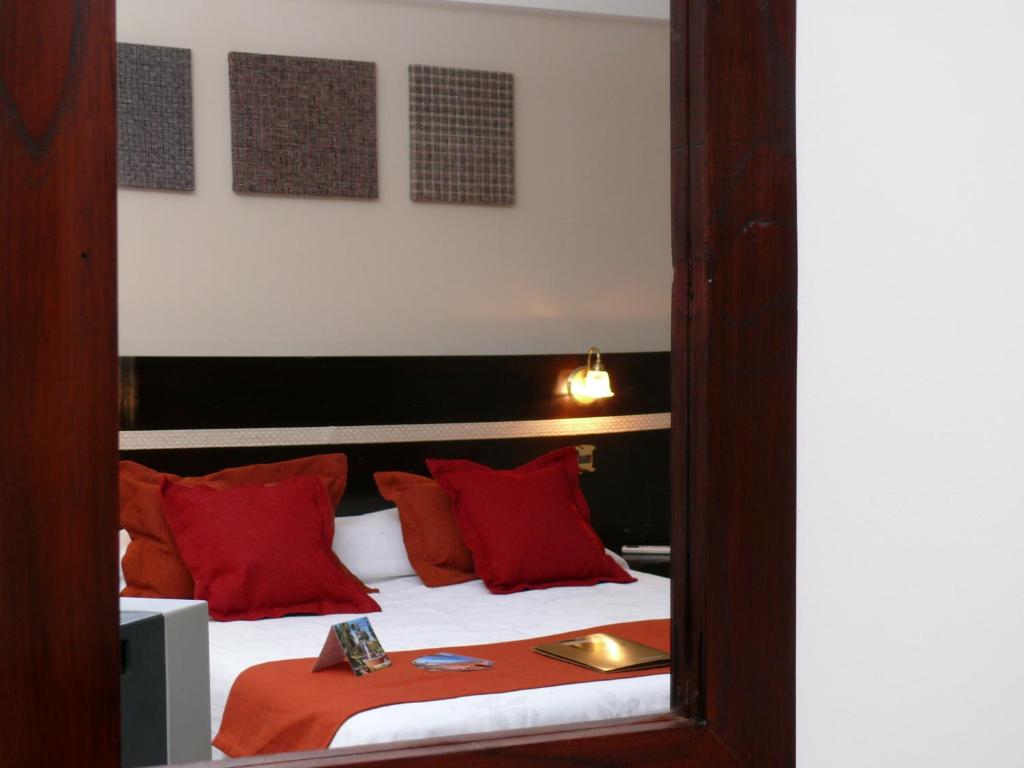 a bed with two pillows and a mirror at Gregorio I Hotel Boutique in San Salvador de Jujuy