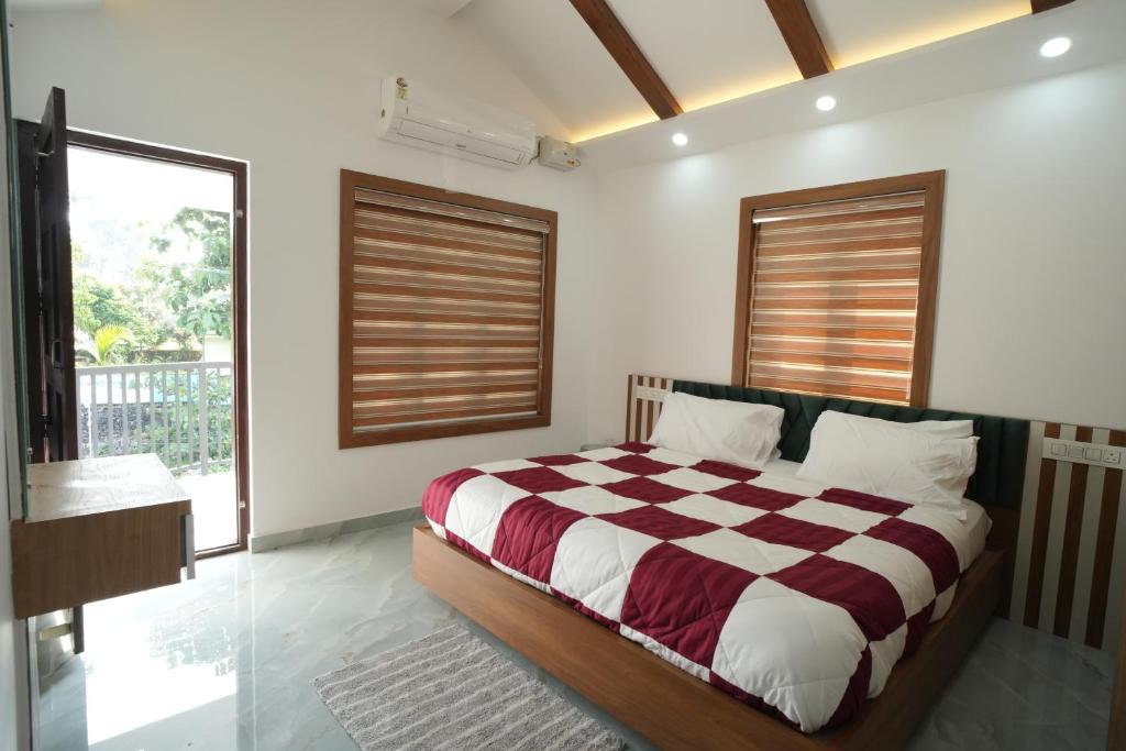 a bedroom with a bed and a large window at Wayanadan Huts Homestay in Sultan Bathery