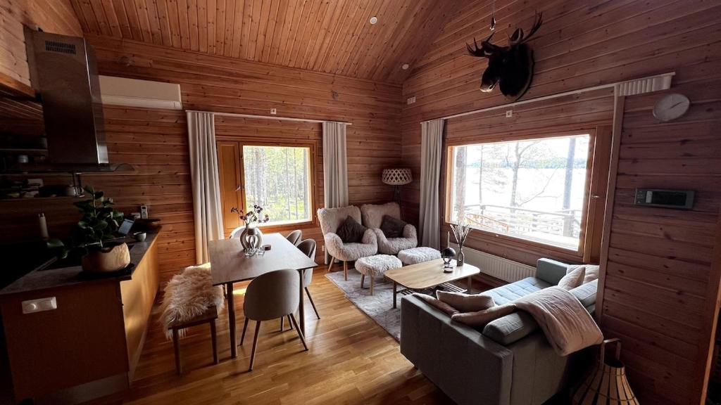 a living room with a couch and a table and chairs at Cozy Arctic Lakeside Cottage with private sauna in Pello