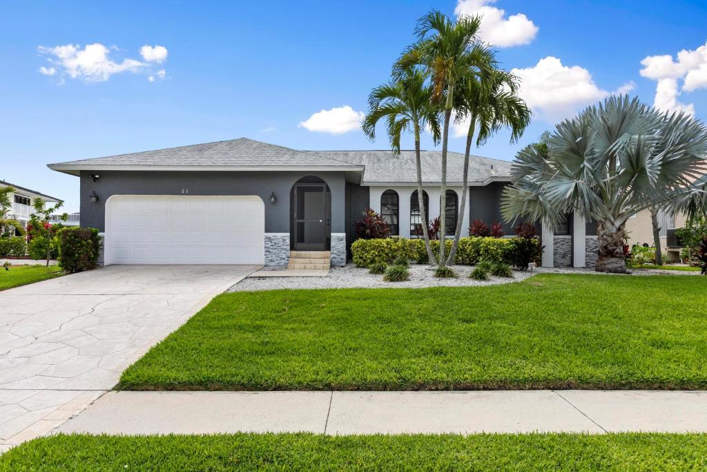 Marco IslandにあるWaterfront Island Mirrorageのヤシの木が茂るガレージ付き家