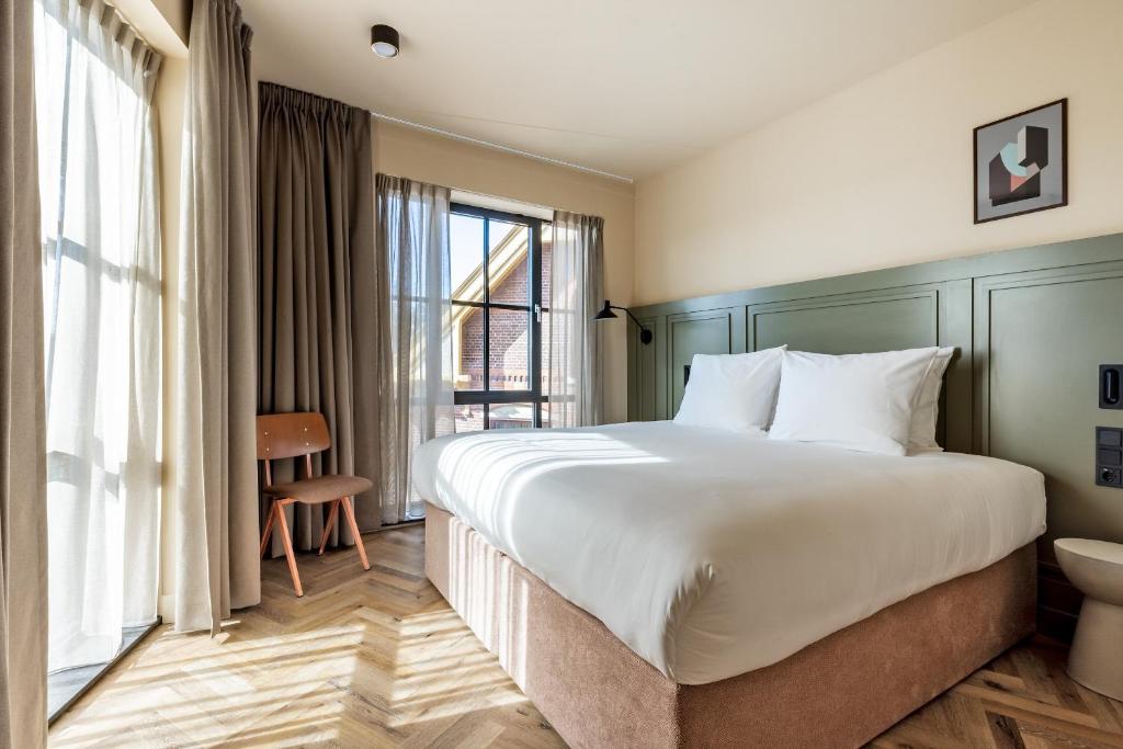 a hotel room with a large bed and a window at Metzlr House in Haarlem