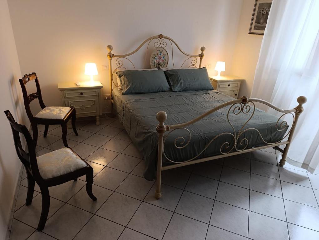 a bedroom with a bed and a chair and two tables at Book Nook Pisa, nei pressi dell'Ospedale di Cisanello e dell'Aeroporto in Cascina