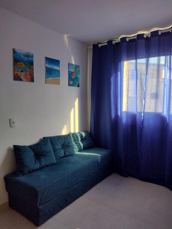 a blue couch in a room with a window at WK Flat em Porto de Galinhas in Porto De Galinhas