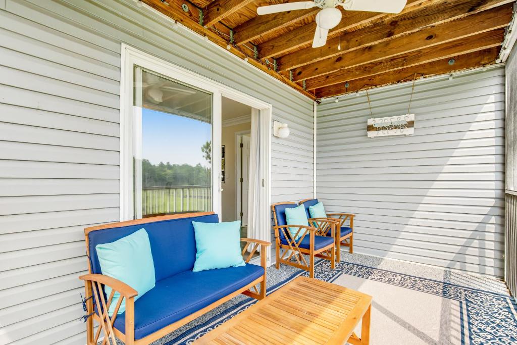 a porch with two blue chairs and a table at Bethany Bay - 8004 Pettinaro Dr in Cedar Shores