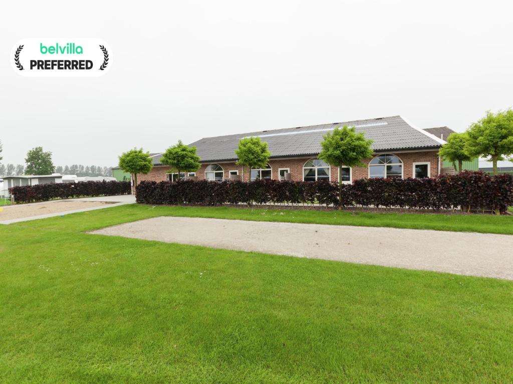 a house with a green lawn and a sidewalk at Apartment in Groede near the Beach in Groede