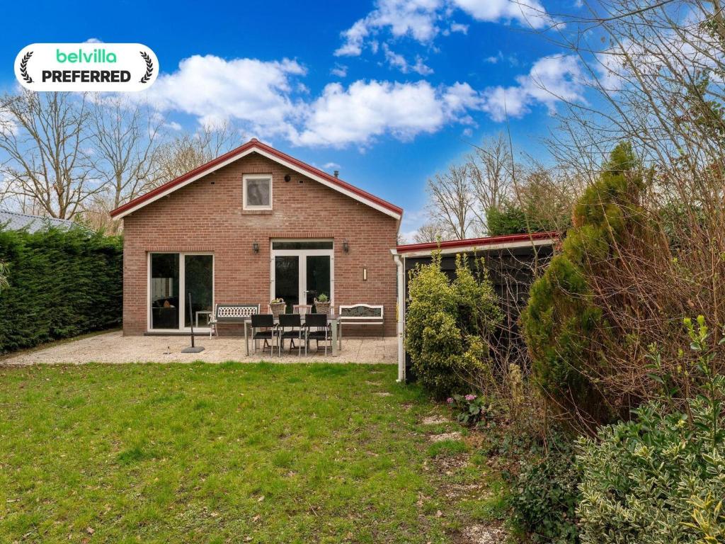 a house with a patio and a lawn at Holiday Home in Zeeland near Lake in Baarland