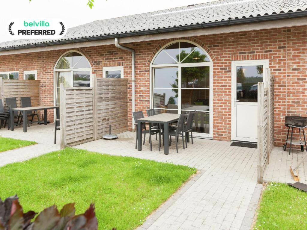 a patio with a table and chairs in front of a brick building at Apartment in Groede near the Beach in Groede