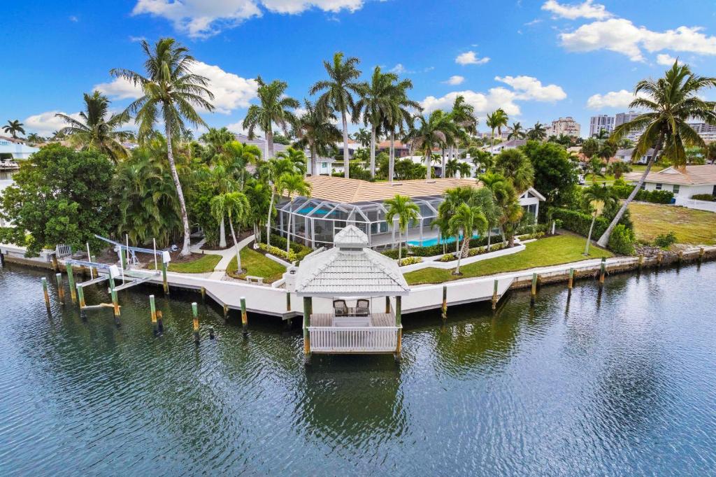 Marco IslandにあるGazebo Pointのヤシの木が茂る水辺の桟橋にある家