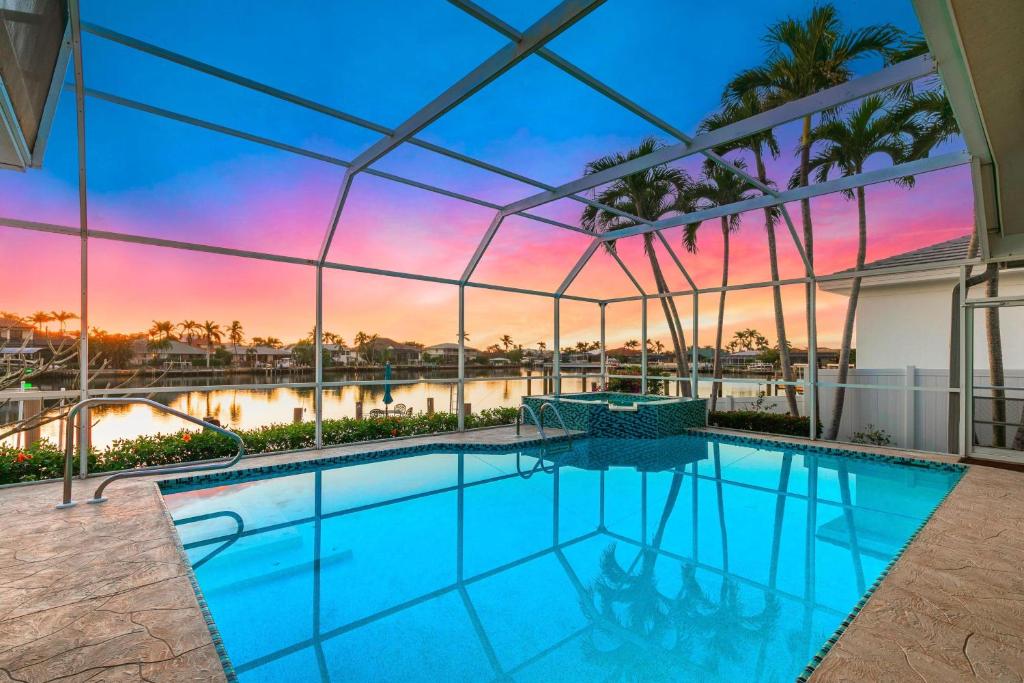 an indoor swimming pool with a view of the sunset at Island Twilight Delight in Marco Island