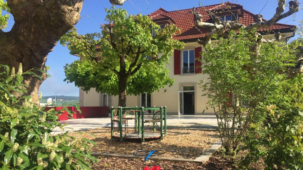a green playground in front of a house at La Belle-Croix in Romont