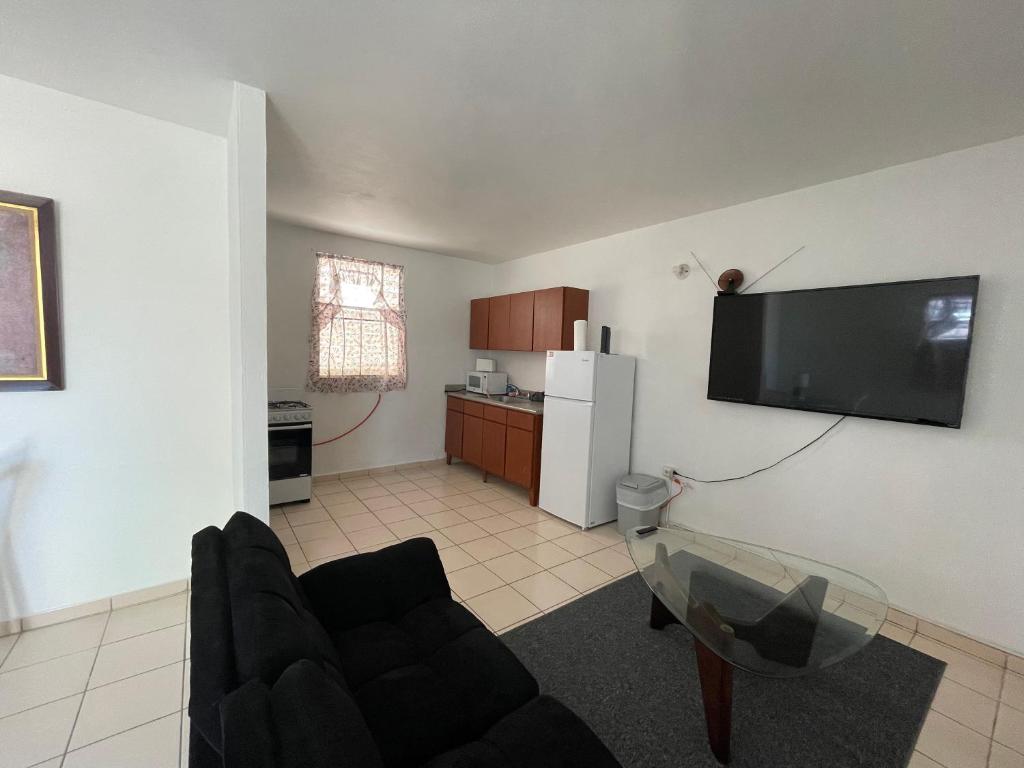 a living room with a couch and a tv on a wall at Cozy Basic Apartment in Levittown in Levittown