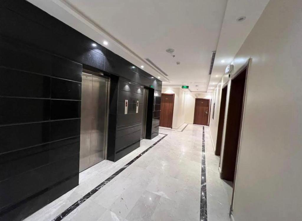 a hallway with black and white walls and a long corridor at فندق شركة وردة الوادي توصيل من والي الحرم 24 مجاني in An Naqāʼ