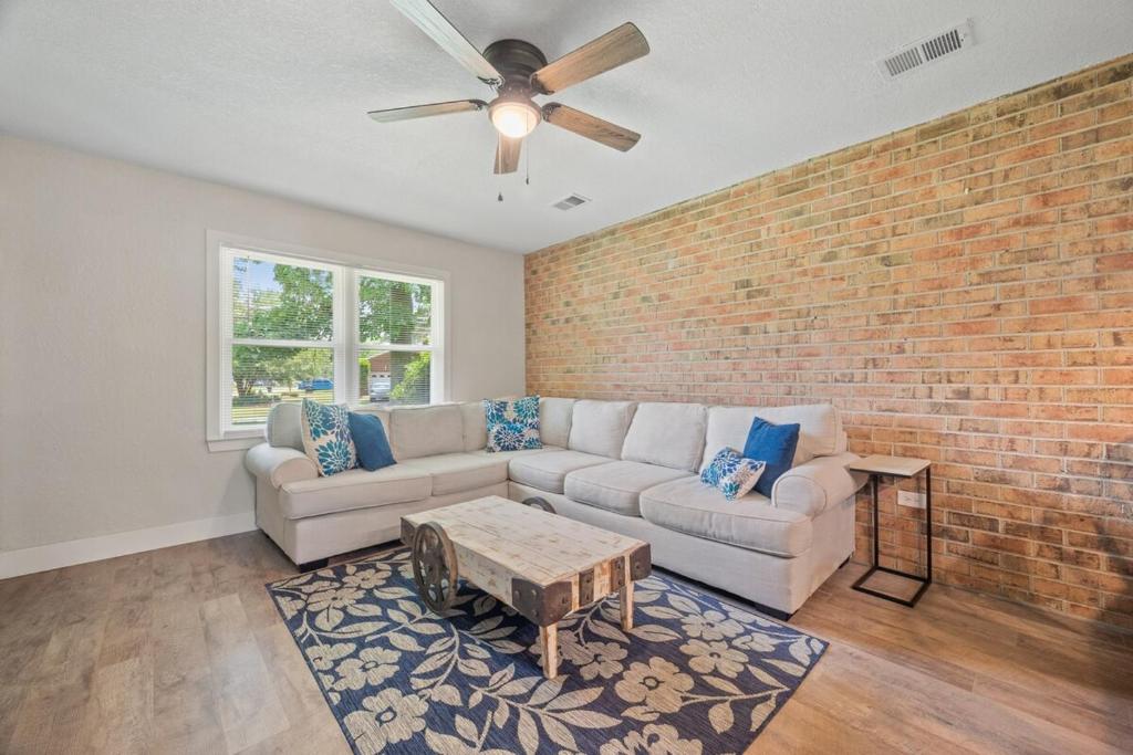 a living room with a couch and a brick wall at Modern 2 Bedroom Home with Fire Pit, Bikes in Portsmouth