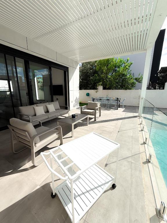 a patio with chairs and a table and a pool at וילת Velizabeth in Omen
