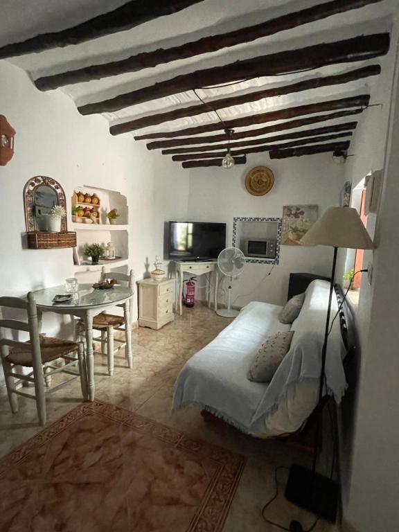 a bedroom with a bed and a desk and a table at Casa Miguelito in Comares