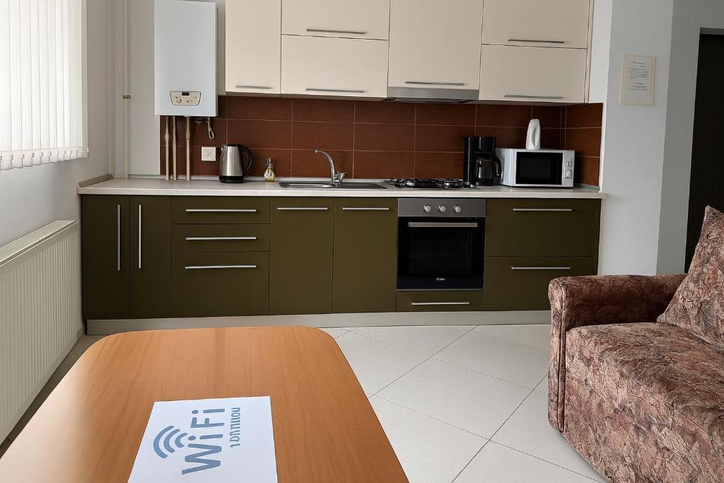 une cuisine avec une table et un panneau. dans l'établissement Apartament,4 paturi, 2 dormitoare,Living cu bucatarie, à Sibiu