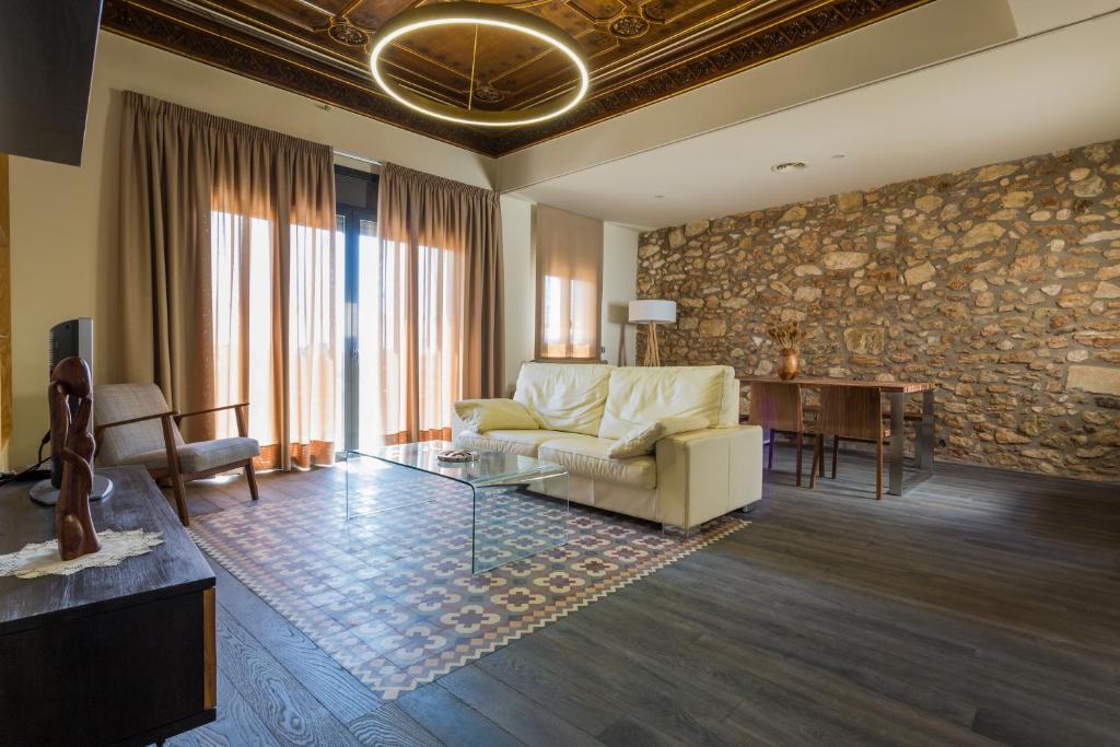 a living room with a couch and a stone wall at Apartament Major 33 in Arbós