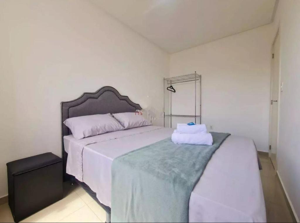 a bedroom with a large bed with white sheets at Apê da Thais in Balneário Camboriú