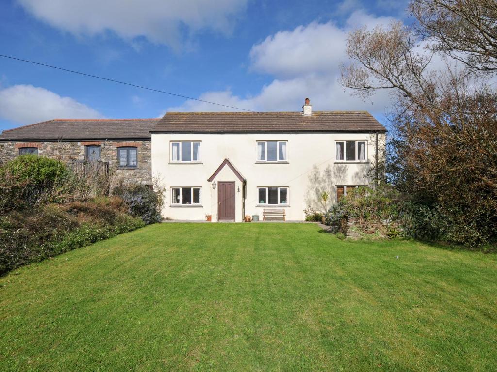 una gran casa blanca con un gran patio en Rosewin Farmhouse, en Saint Minver