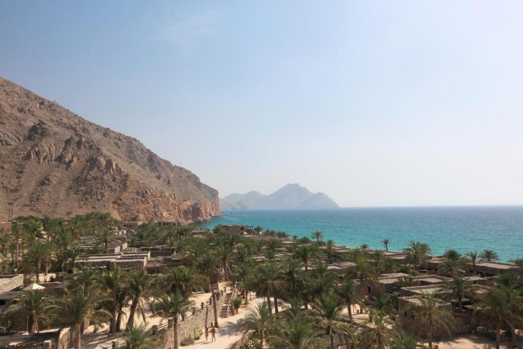 ディバにあるSix Senses Zighy Bayのヤシの木と海のビーチ