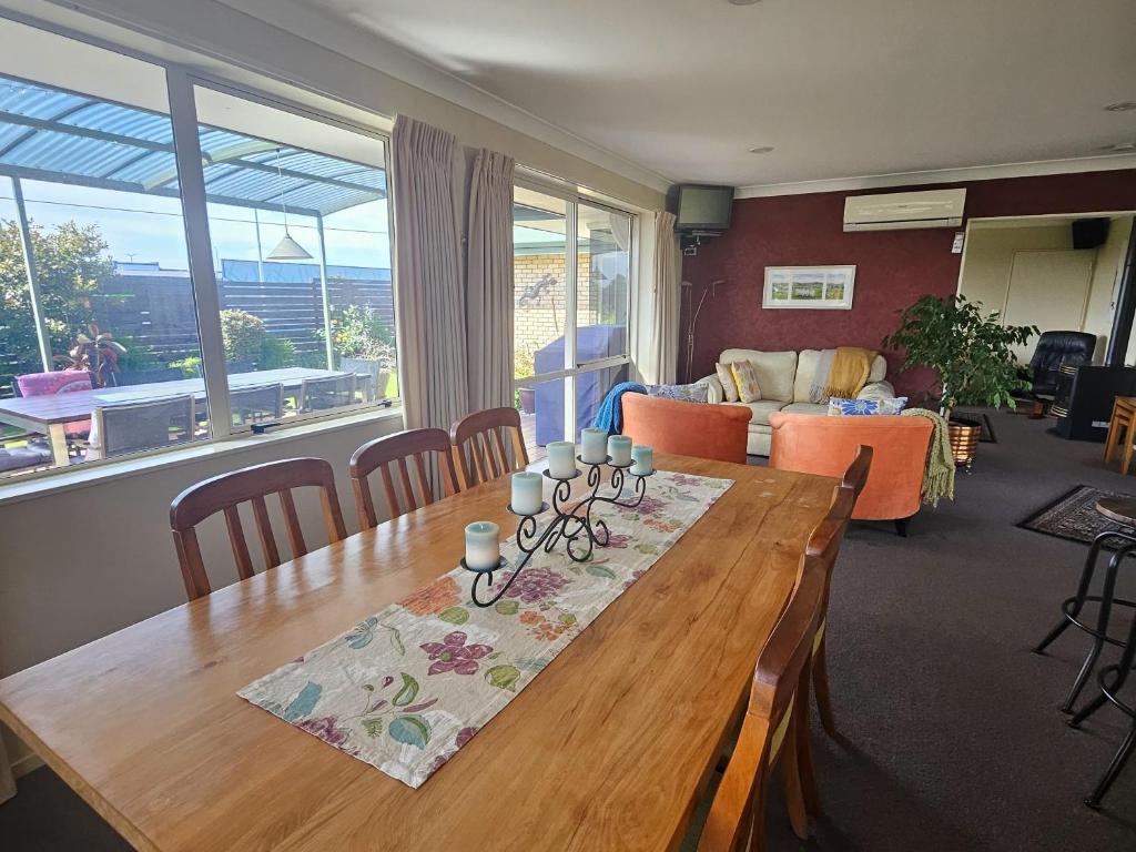 a living room with a wooden table and a couch at The Holiday Haven in Tauranga