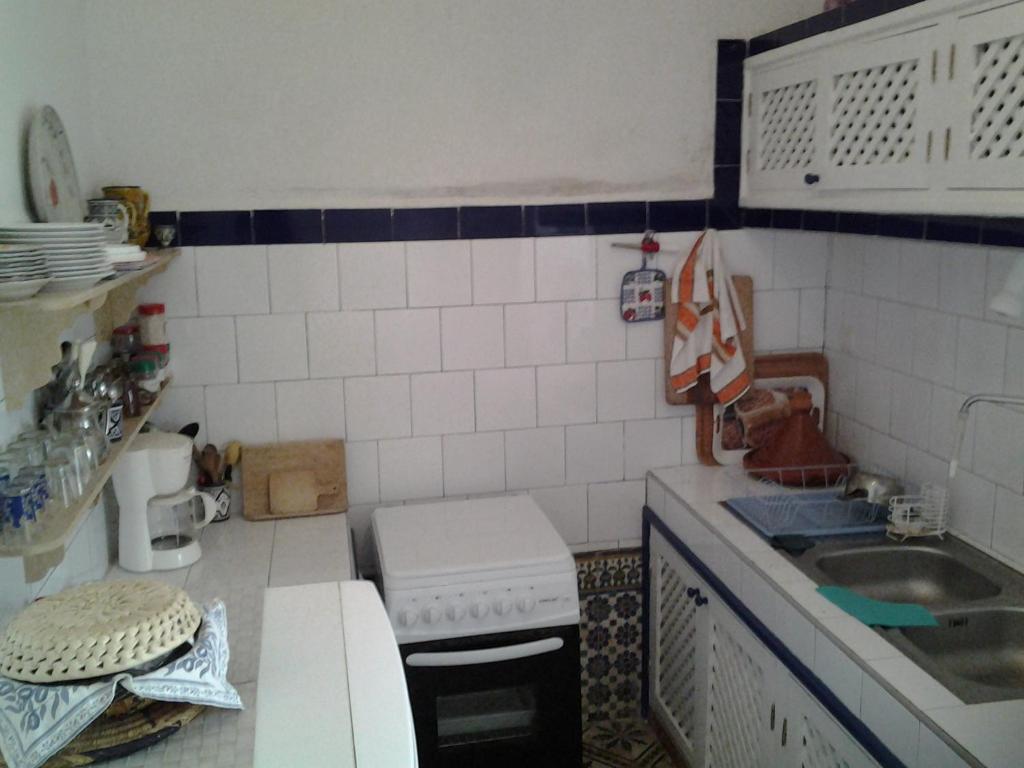 a small kitchen with a sink and a stove at Dar Gentille in Essaouira