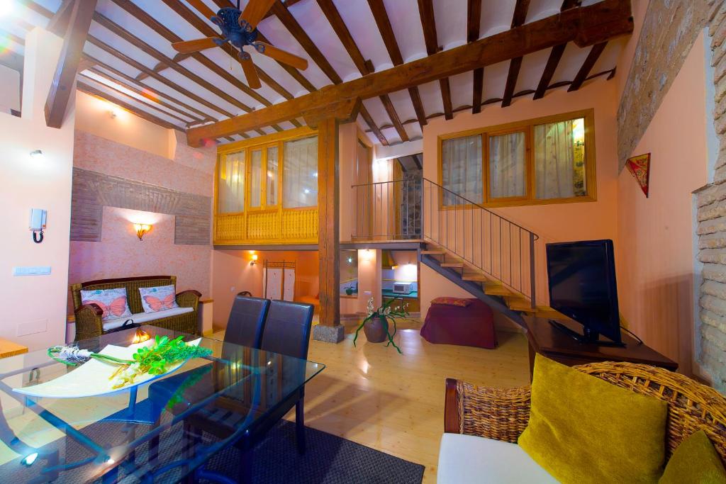 a living room with a table and a staircase at Casa de la Mezquita y Casa de Carretas MeninasCollection in Toledo