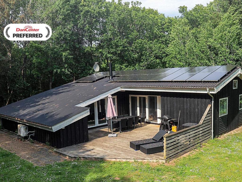 a large black building with a deck and a house at 8 person holiday home in Ålbæk-By Traum in Ålbæk