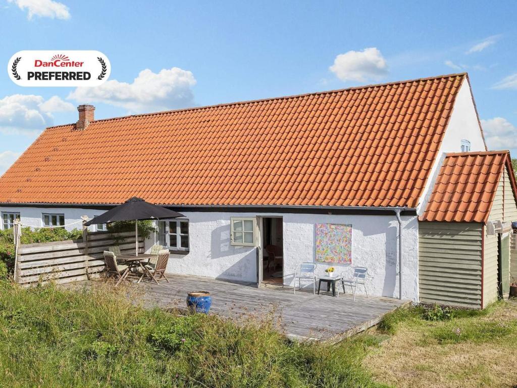 a white house with an orange roof and a deck at Historic Charm by Lild Strand-By Traum in Frøstrup
