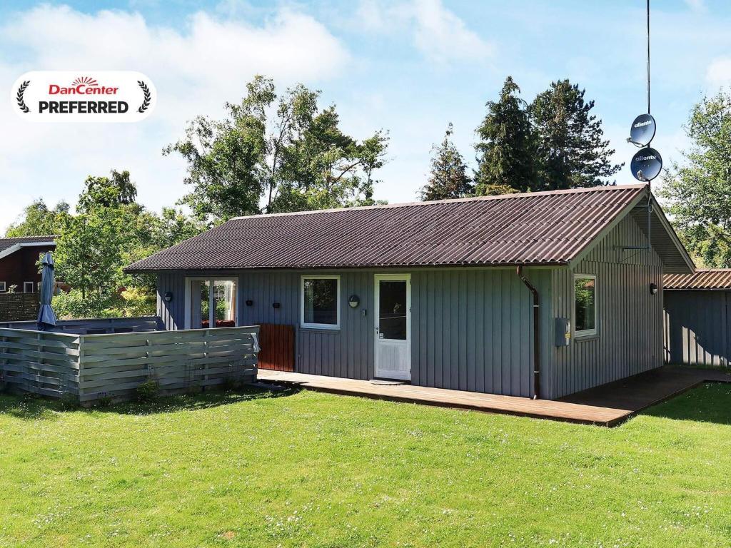 a small green shed with a porch on a yard at 6 person holiday home in Gedser-By Traum in Gedser
