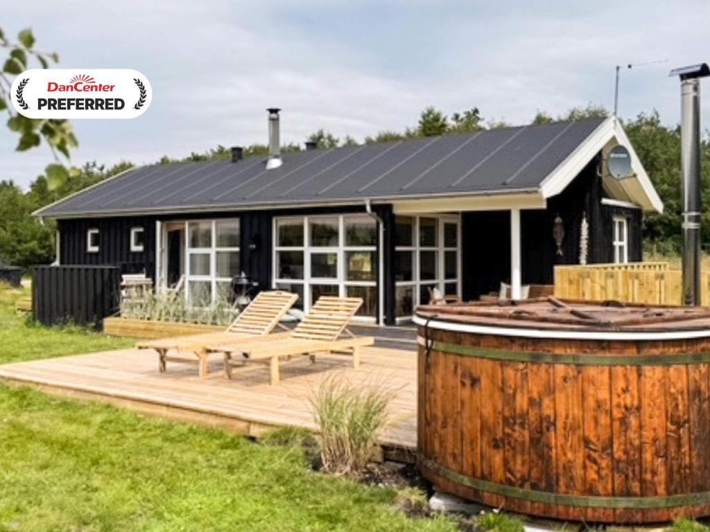 a house with a picnic table and a barrel at 6 person holiday home in Øster Assels-By Traum in Sillerslev