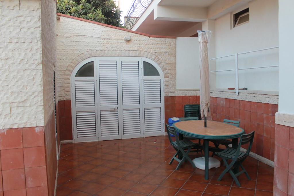 une terrasse avec une table et des chaises devant un bâtiment dans l'établissement La Piccola Musa, à Fontane Bianche