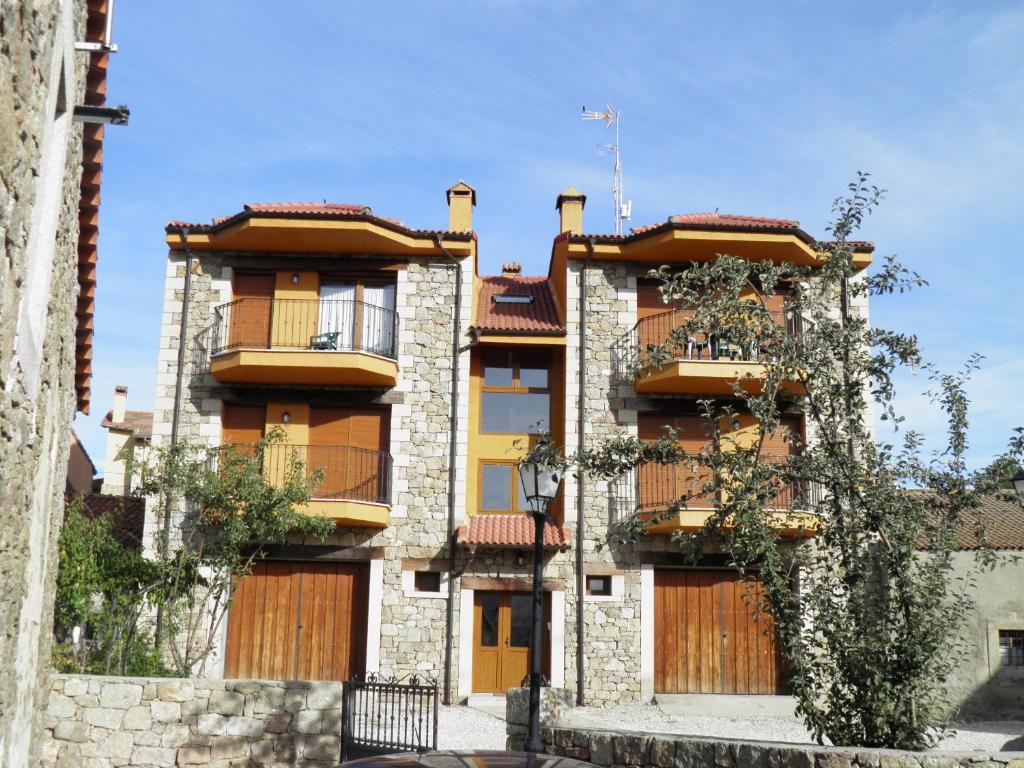 apartamentowiec z drewnianymi drzwiami i oknami w obiekcie Mirasierra II Y III w mieście Navarredonda de Gredos