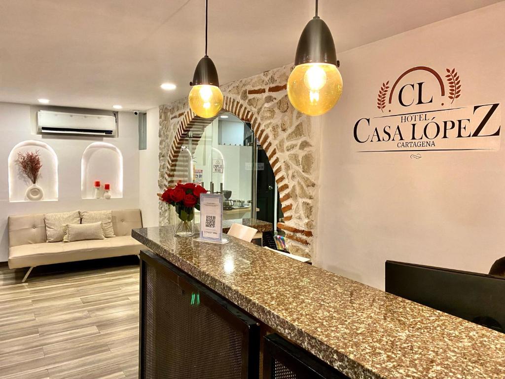 Un vestíbulo con mostrador y sala de estar. en Hotel Casa Lopez - Cartagena, en Cartagena de Indias
