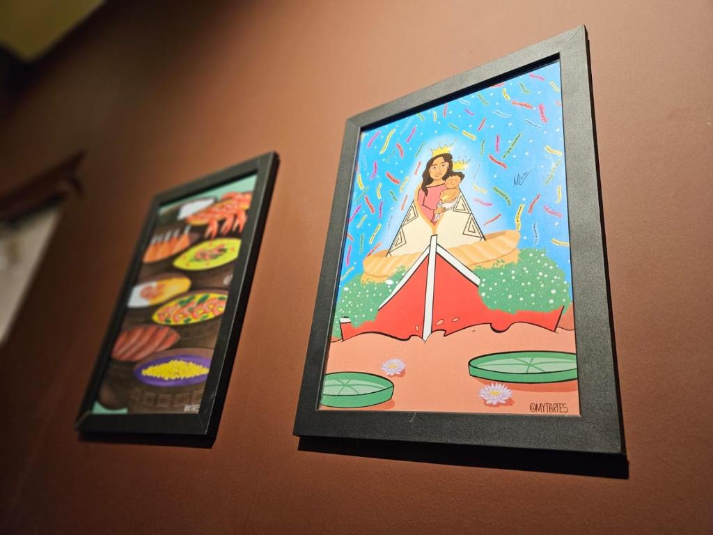 two framed pictures of a woman on a wall at Praculá Hotel in Belém