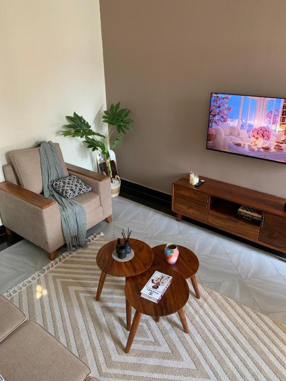 a living room with a flat screen tv on a wall at True's cozy homes in Kira